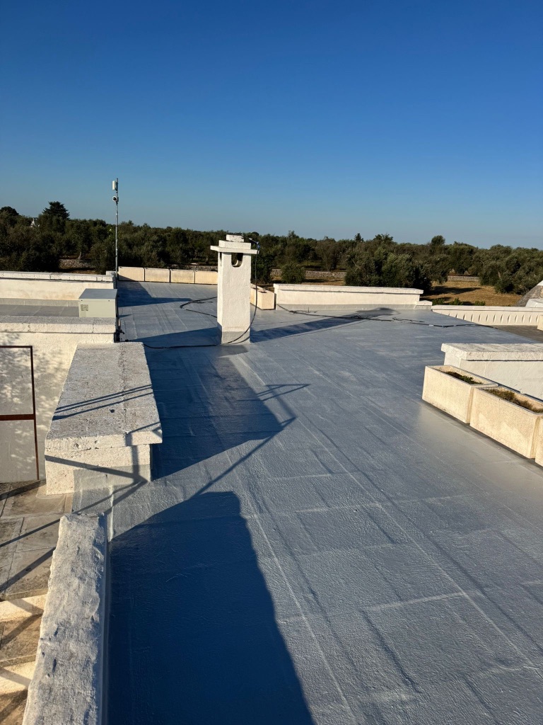 Flat roof after coating — fully finished pale blue-grey surface