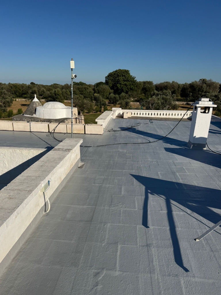 Flat roof after coating — fully finished pale blue-grey surface