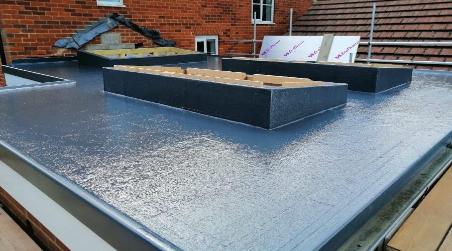 Liquid-applied waterproofing being installed on a flat roof